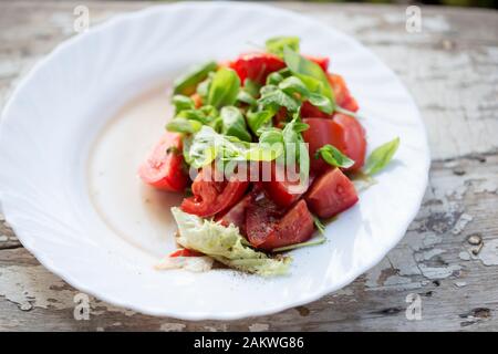 Salade de tomates avec laitue, basilic et vinaigrette Banque D'Images