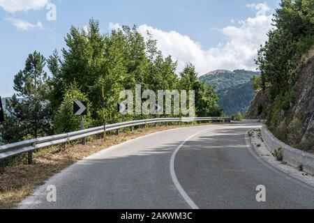 Paysage avec flexion de route parmi les bois vallonnés, tourné dans un lumineux soleil d'été lumineux près de Paterno, Salerne, Campanie, Italie Banque D'Images