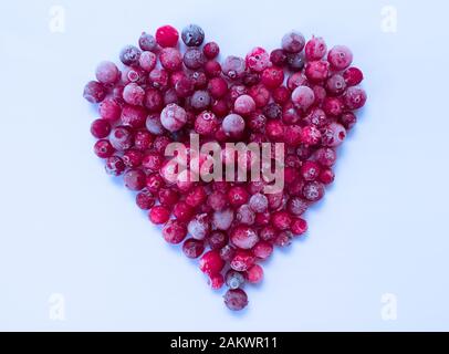Coeur fait de baies de canneberges surgelées sur fond blanc. Banque D'Images