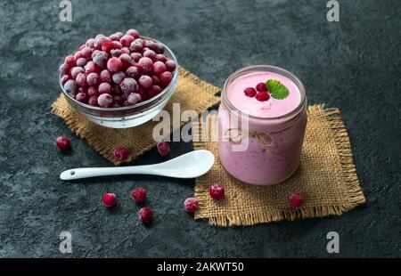 Yaourt glacé aux canneberges sur fond noir. Le concept de desserts sains. Banque D'Images