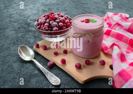 Yaourt glacé aux canneberges sur fond noir. Le concept de desserts sains. Banque D'Images