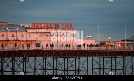 Brighton UK 10 Janvier 2020 - rassembler les foules sur Palace Pier de Brighton pour regarder un coucher de soleil spectaculaire aussi humide et venteux devrait revenir à l'échelle du pays d'ici quelques jours . Crédit : Simon Dack / Alamy Live News Banque D'Images
