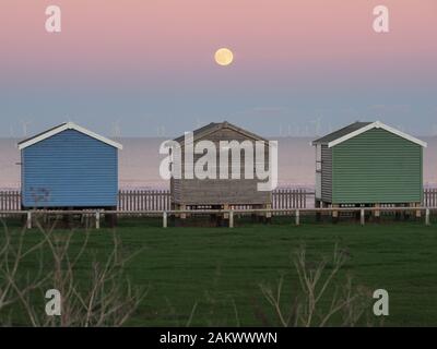 Leysdown, Kent, UK. 10 janvier, 2020. Météo France : la pleine lune Loup vu monter au-dessus des cabines de plage en Leysdown, Kent ce soir. Credit : James Bell/Alamy Live News Banque D'Images