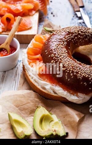 Brunch festif avec saumon fumé servi avec fromage à la crème, bagel, pot de caviar de saumon, avocat, table rustique près Banque D'Images