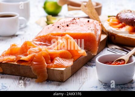 Brunch festif avec saumon fumé servi avec fromage à la crème, bagel, pot de caviar de saumon, avocat, table rustique près Banque D'Images
