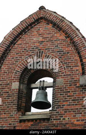 Cloche en métal sur support en bois dans un mur de briques incurvé au centre de Copenhague. Banque D'Images