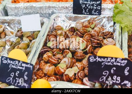 Escargots crus non cuits avec beurre d'ail à vendre sur le marché du poisson. Fruits de mer, marché des mollusques et crustacés. Stock photo escargots avec grands escargots, escargots, farcis avec Banque D'Images