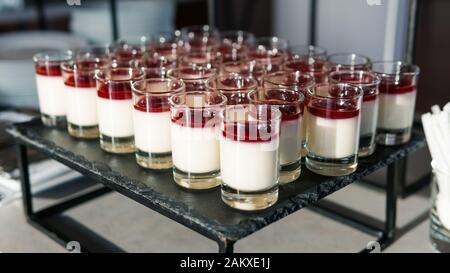 Gros plan de mini desserts au cheesecake servis dans de petites tasses à verres. Concept de restaurant, café et service de restauration Banque D'Images