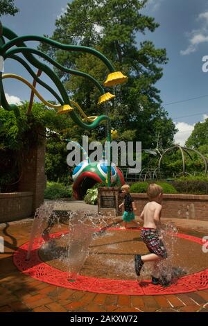 Deux enfants sur une fontaine rafraîchissante dans le jardin d'enfants de l'Atlanta Botanical Garden, Piedmont Park, Georgia, USA Banque D'Images