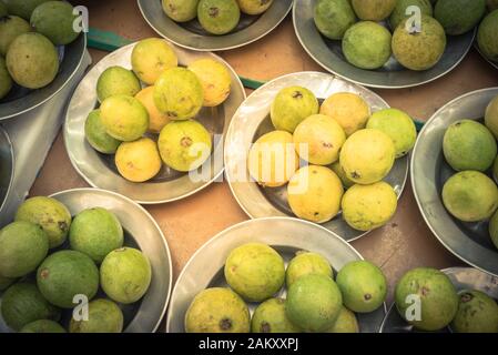 Tas de gouavas frais et crus mûrs sur des plateaux en aluminium sur le marché local de Singapour Banque D'Images