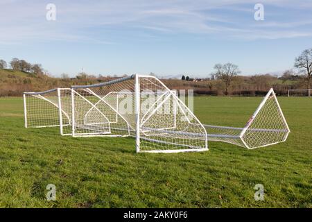 Crick, Northamptonshire, Royaume-Uni: Quatre bouches de football à cinq côtés à cadre blanc et en réseau, qui s'allongés sur l'herbe d'un terrain de jeu en milieu rural. Banque D'Images
