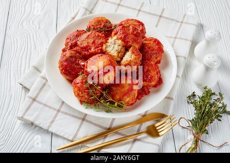 Gros plan des Boulettes de poisson, des boules de poisson frites dans la sauce tomate sur une plaque, vue horizontale d'en haut Banque D'Images