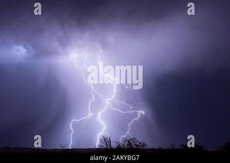 Un éclair lumineux illumine une colonne de pluie tombant d'un orage près de Cordes Lakes, Arizona, États-Unis Banque D'Images