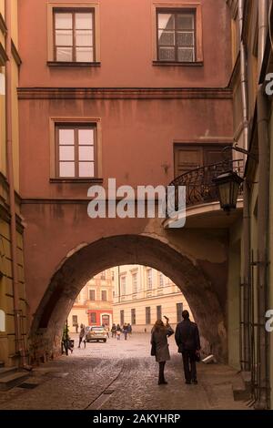 Un couple regarde l'une des nombreuses arches dans la vieille ville de Lublin, Pologne Banque D'Images