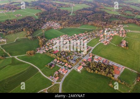 Vue aérienne de la petite ville avec leur toit de tuiles rouges parmi les champs et vert forêt lointaine en été. Banque D'Images