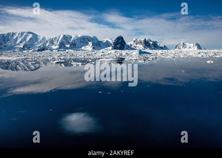 Canal Lemaire vu par un jour ensoleillé avec montagnes, glaciers et glace reflétées dans l'océan, Antarctique Banque D'Images