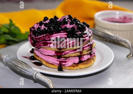 Les crêpes ont servi de la crème avec du fromage cottage et des bleuets sur un beau plateau en bois, à côté de la confiture de bleuets et de la menthe, beau fond, vue latérale Banque D'Images