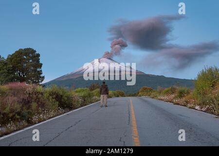 Jeune homme se tenant sur la route du volcan Popocatepetl au Mexique au lever du soleil Banque D'Images