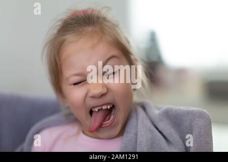 Closeup portrait of smiling funny little Girl with Tongue Out et sans une dent de devant Banque D'Images