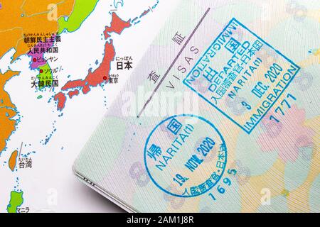 Une page intérieure d'un passeport sur un cachet d'entrée au Japon avec une carte asiatique sur le fond Banque D'Images