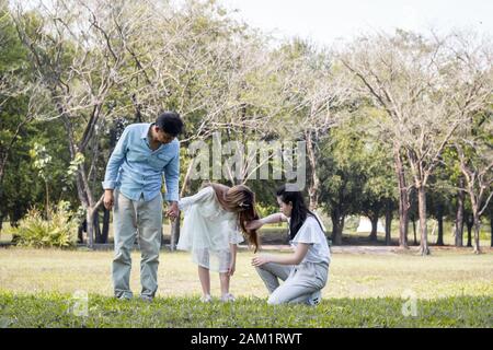 Le père et la mère prennent soin des enfants dans le parc. Banque D'Images