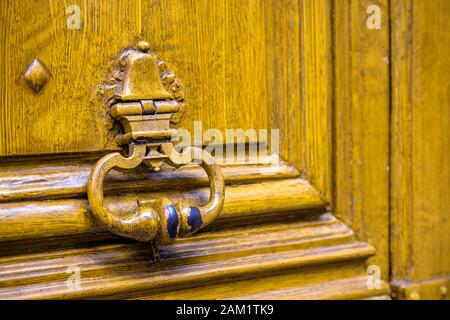 Fragment d'ancienne porte en bois peinte en jaune avec une peinture écaillée et un pommeau de poignée en métal forgé comme symbole de communication et de protection de privat Banque D'Images