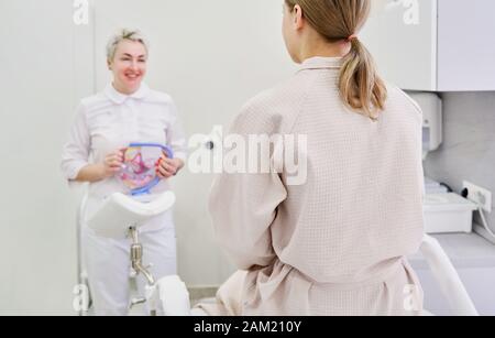 Médecin gynécologue consulting un patient à l'aide de modèle de l'anatomie de l'utérus Banque D'Images