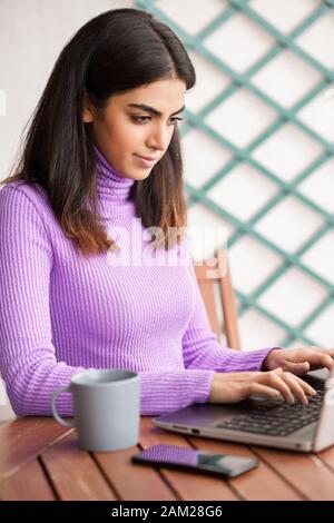 Persian femme sur son balcon à l'aide d'un ordinateur portable Banque D'Images