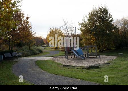 Bancs de parc et aire de jeux pour enfants dans la nouvelle ville, Borschemich Neu, Allemagne Banque D'Images