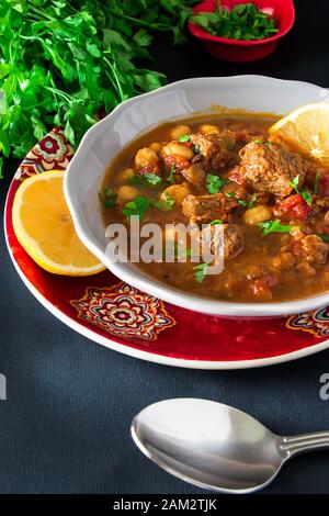 Soupe marocaine à la viande, aux pois chiches, aux lentilles, aux tomates et aux épices. Copieux, parfumé. Préparation pour Iftar dans le mois Saint du Ramadan Banque D'Images