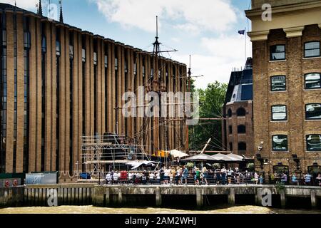 River Thames Londres Royaume-Uni. Réplique de Golden Hind montrant des gens assis à l'extérieur du Old Thameside Inn London Banque D'Images