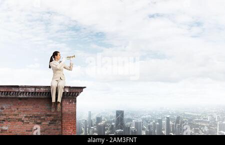 Attractive young woman playing trumpet sur toit Banque D'Images