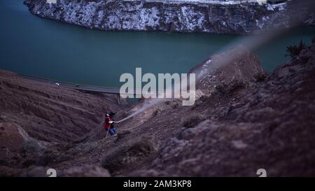 Xining. Jan 7, 2020. Wang Qingbo grimpe une montagne lors d'une mission de patrouille dans le nord-ouest de la province de Qinghai en Chine, le 7 janvier 2020. Wang Qingbo et ses collègues sont responsables de l'inspection et la réparation des principaux réseaux de Salar de Xunhua comté autonome, Hui comté autonome de Hualong et des lignes de transmission d'énergie d'Gongboxia power station dans l'est de Qinghai.Pour fixer le bloc d'alimentation dans la région, ils ont pour patrouiller sur les montagnes escarpées qui la population locale décrite comme 'razor ridge". Credit : Wu Gang/Xinhua/Alamy Live News Banque D'Images