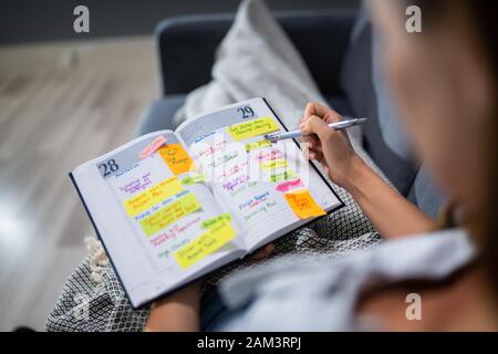 Close-up of Woman Writing Note importante Dans Journal avec stylet Banque D'Images