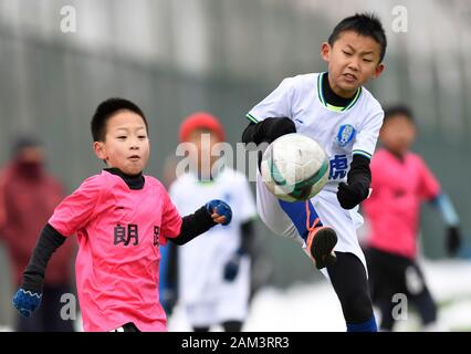 (200111) -- BEIJING, 11 janvier 2020 (Xinhua) -- Liu Yuze (R) de Tiger Club's U10 rivalise avec l'équipe de Yan Zixuan Langyue Club U10 team lors de leur match à 2019-2020 Football Club des jeunes de Beijing à Beijing de la Ligue, capitale de la Chine, le 11 janvier 2020. (Xinhua/Wu Wei) Banque D'Images