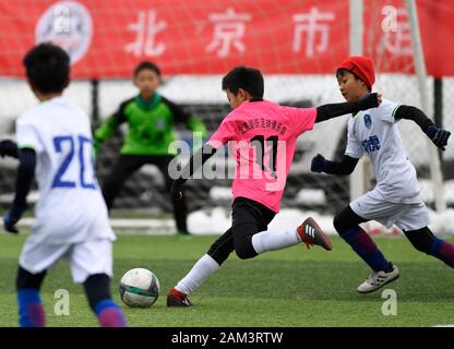 (200111) -- BEIJING, 11 janvier 2020 (Xinhua) -- Wang Zhi (C) de Langyue Club U10 équipe tire le ballon lors du match contre Tiger Club's U10 à l'équipe de football des jeunes de Beijing 2019-2020 Ligue Club à Beijing, capitale de Chine, le 11 janvier 2020. (Xinhua/Wu Wei) Banque D'Images