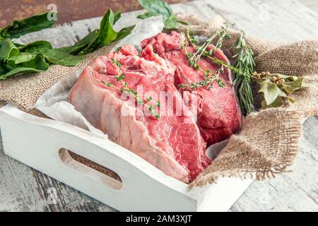 La côtelette de viande est prête à mariner et à cuisiner sur le barbecue. La viande est stockée sans plastique, dans du papier et du tissu respectueux de l'environnement. Gros plan. Banque D'Images