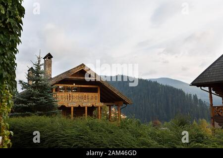 Maisons en bois vintage dans le centre touristique avec des boubreux, des herbes d'automne et des plantes autour. Alpain pittoresque de la maison de bois de campagne dans le sapin Banque D'Images