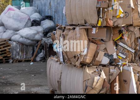 Balles de carton et fort avec les serre-fils de cerclage. Arrière-plan de textures de papier empilés prêts à recycler. Banque D'Images