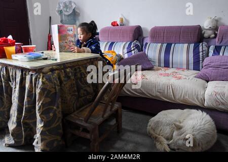 (200111) -- CHANGSHA, 11 janvier 2020 (Xinhua) -- la fille de Mei Xiang Yang commentaires Wenxuan ses leçons à Pinglang Village de Saint Paul Ville de Xiangxi préfecture autonome tujia et miao de la Chine centrale, la province du Hunan, le 8 janvier 2020. La famille de Mei Xiang a secoué la pauvreté et commencé une nouvelle vie puisqu'ils déplacé hors de la zone montagneuse et réinstallées dans nouvelle résidence avec de meilleurs milieux naturels et les conditions de vie au village Pinglang déménagement local au cours des programmes pour les villageois pauvres à la fin de 2017. Xiang, 34 ans, a gagné son premier emploi comme femme de ménage ici. Et ensemble Banque D'Images