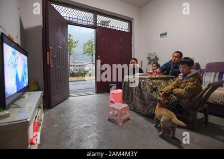 (200111) -- CHANGSHA, 11 janvier 2020 (Xinhua) -- Xiang Mei regarde la télévision avec sa famille à Pinglang Village de Saint Paul Ville de Xiangxi préfecture autonome tujia et miao de la Chine centrale, la province du Hunan, le 8 janvier 2020. La famille de Mei Xiang a secoué la pauvreté et commencé une nouvelle vie puisqu'ils déplacé hors de la zone montagneuse et réinstallées dans nouvelle résidence avec de meilleurs milieux naturels et les conditions de vie au village Pinglang déménagement local au cours des programmes pour les villageois pauvres à la fin de 2017. Xiang, 34 ans, a gagné son premier emploi comme femme de ménage ici. Et, avec son mari, Banque D'Images