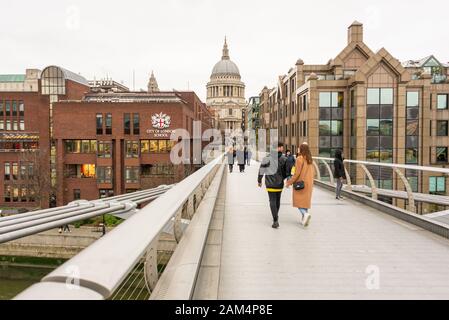 Les gens sur le pont Millennium près de la City of London School et de la cathédrale St Paul, Londres en hiver Banque D'Images
