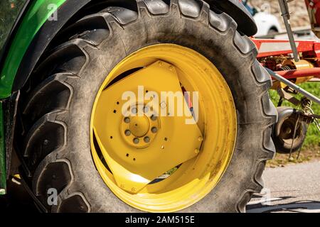 Gros plan d'une grande roue jaune d'un tracteur à pneus noirs, machines agricoles Banque D'Images