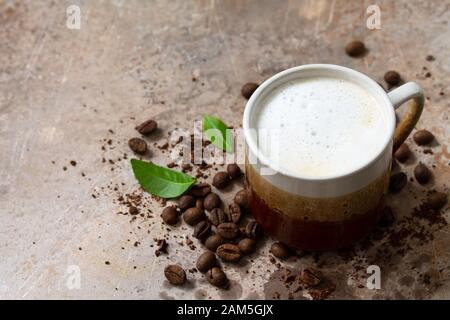 Concept de café du matin. Tasse de café Latte et de grains de café sur un comptoir en pierre en béton. Espace de copie. Banque D'Images