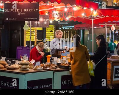 Les clients achetant du pain à Oliver's Bakery dans Borough Market, Southwalk, Londres Banque D'Images