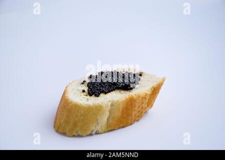 un sandwich au caviar noir isolé sur le fond blanc Banque D'Images