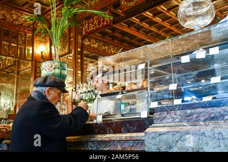 Un homme de haut niveau appréciant son café espresso au comptoir de la place historique Caffé Mulassano sur la place Piazza Castello, Turin, Piémont, Italie Banque D'Images