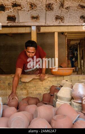 L'homme indien met des pots d'argile dans le four de poterie à Dharavi Slum à Mumbai. Inde Banque D'Images