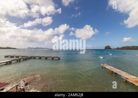 Bois une jetée en béton avec bateaux de pêche en arrière-plan à Calliaqua, Saint-Vincent, Saint-Vincent-et-les Grenadines Banque D'Images