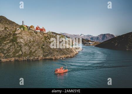 Des maisons colorées parsement les collines de la ville de pêcheurs de Kangaamiut, à l'ouest du Groenland. Icebergs du glacier de Kangia au Groenland nageant avec le ciel bleu Banque D'Images